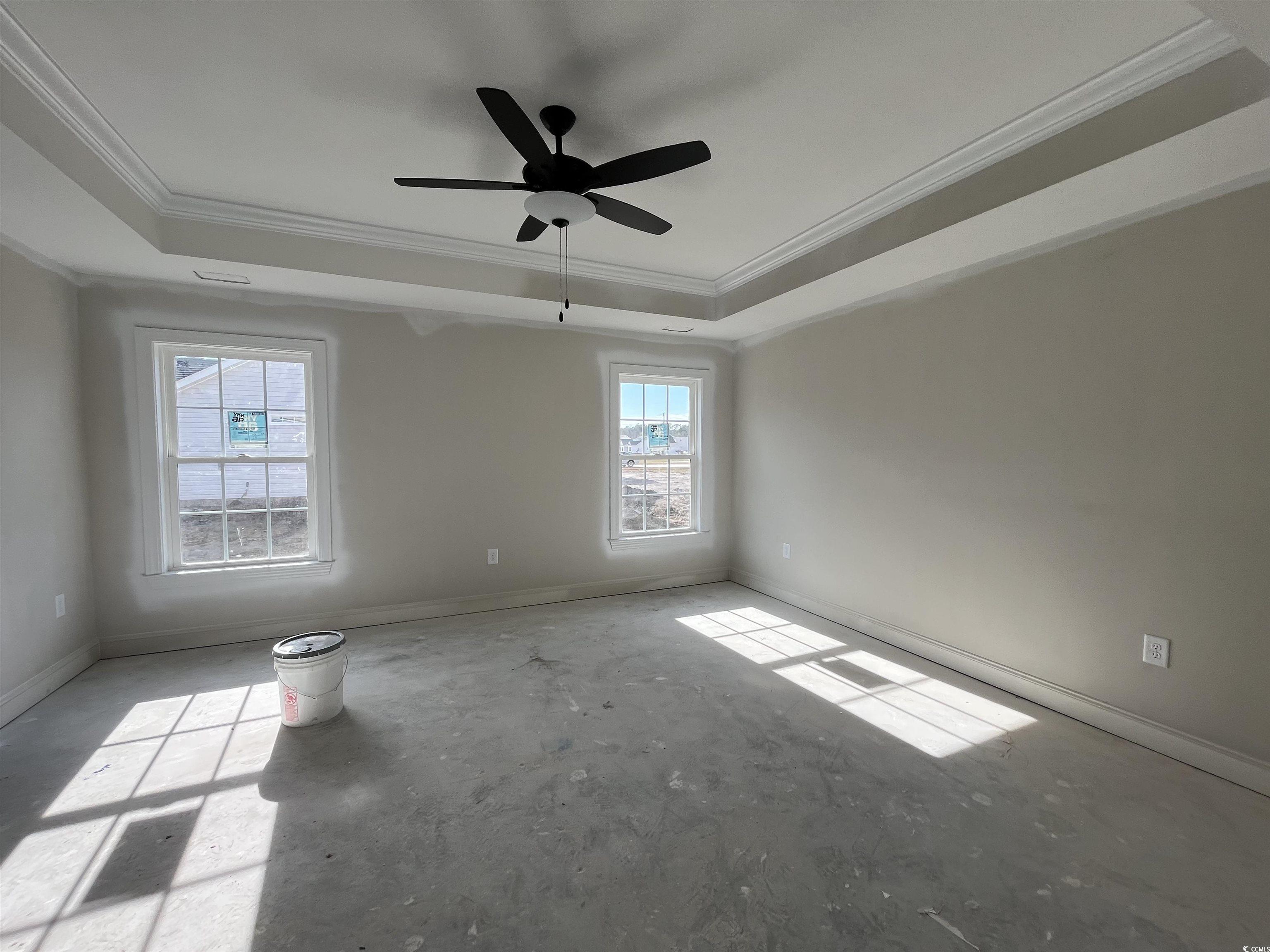 3255 Red Bluff Road Loris, SC 29569 - Photo 5 of 38 Empty room with crown molding, ceiling fan, a raised ceiling, and concrete flooring