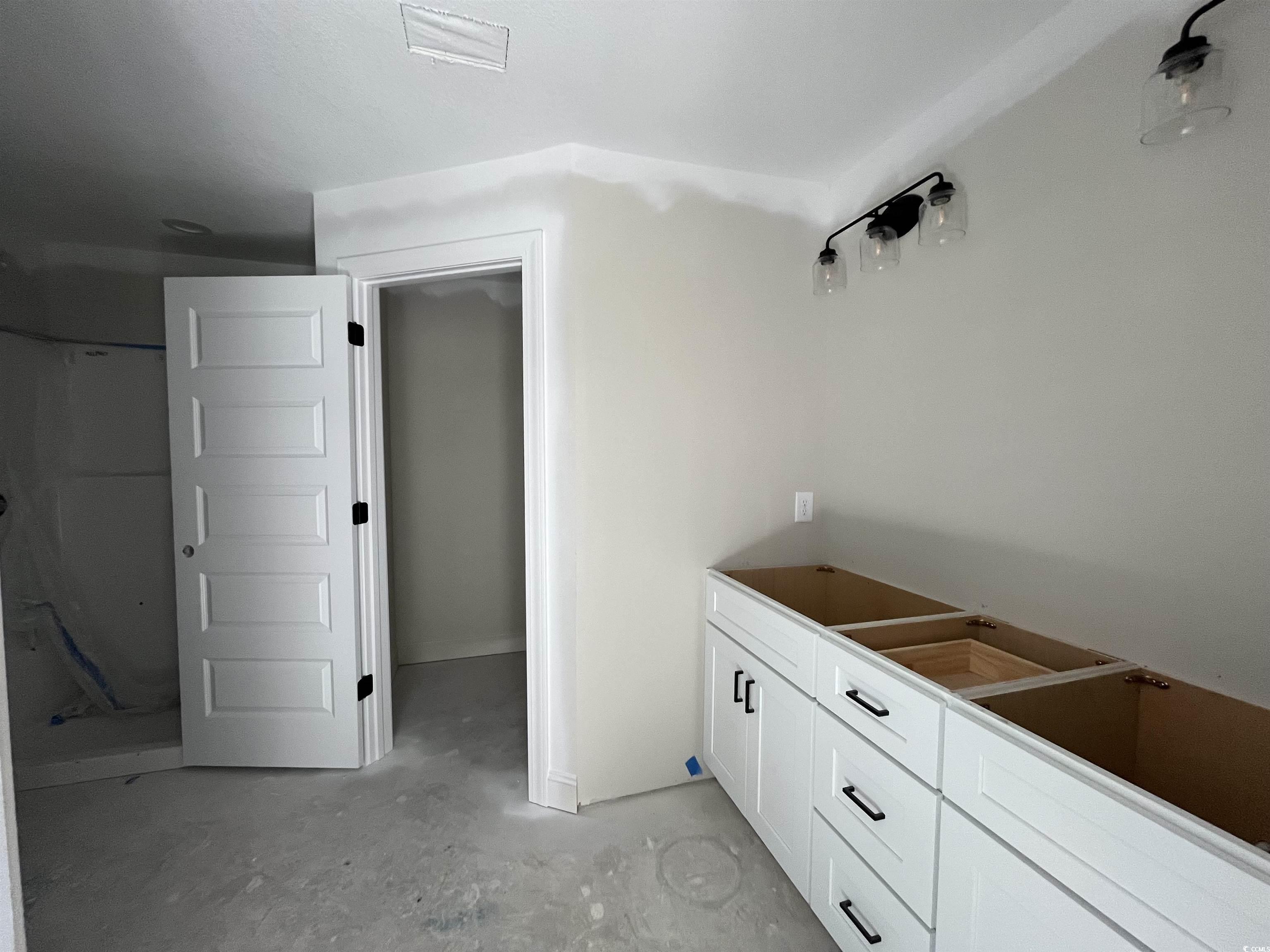 3255 Red Bluff Road Loris, SC 29569 - Photo 9 of 38 Bar with unfinished concrete floors and white cabinets