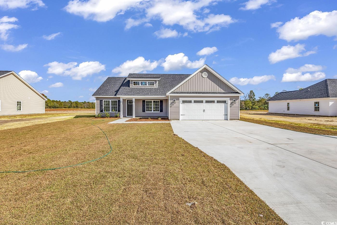 3255 Red Bluff Road Loris, SC 29569 - Photo 10 of 38 View of front facade with driveway, a front lawn, a shingled roof, an attached garage, and board and batten siding