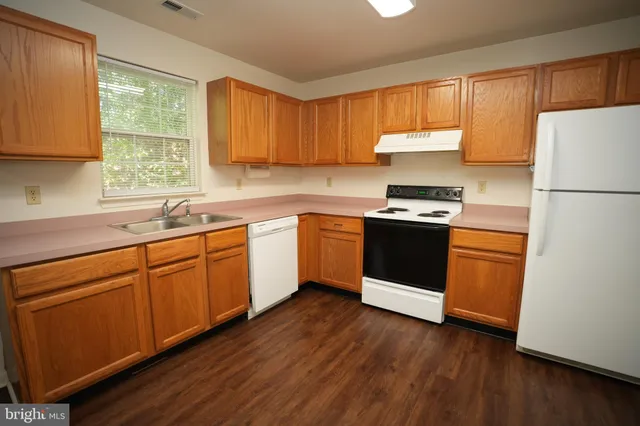 a kitchen with a white cabinets a sink a window and stainless steel appliances