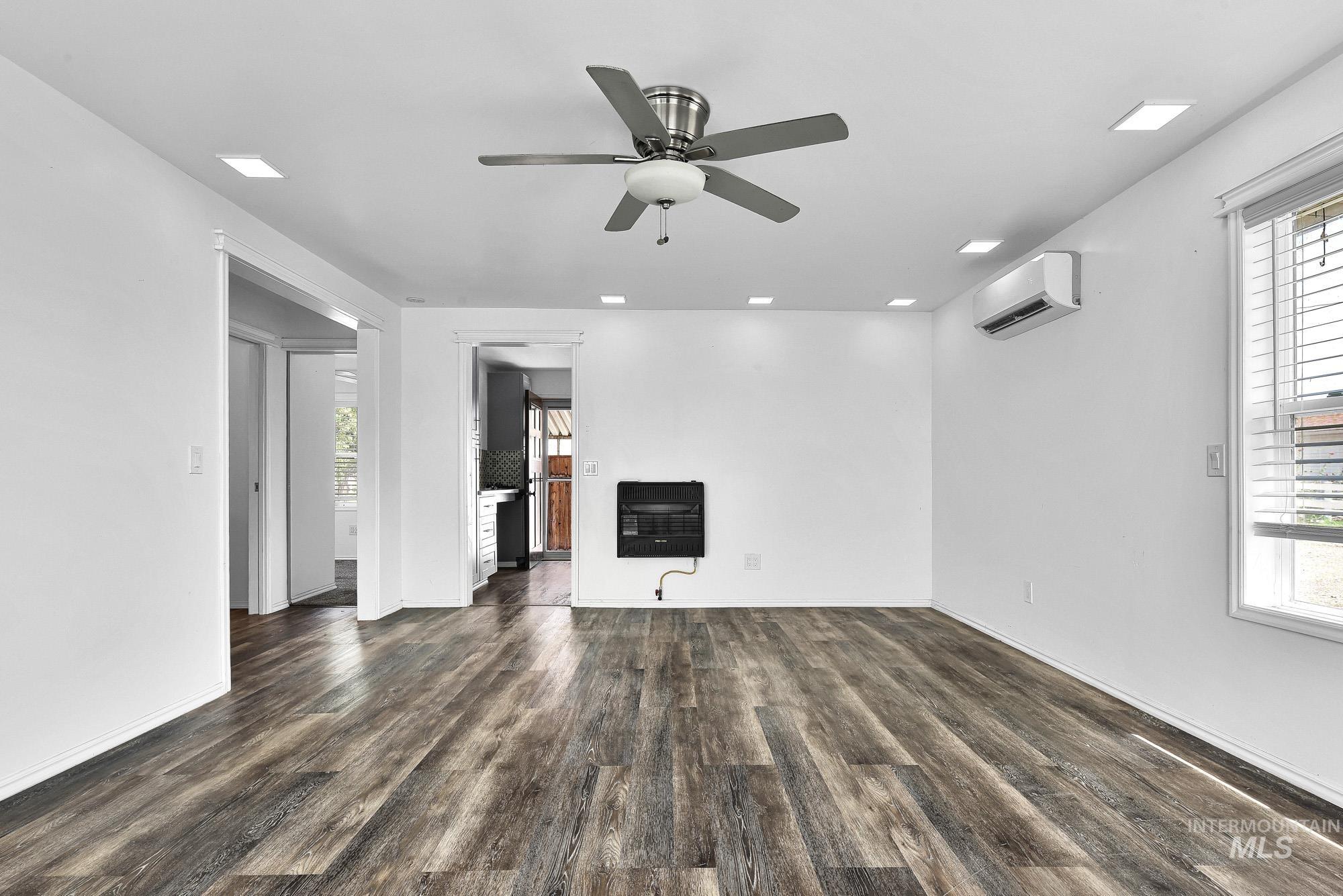 24900 Market Road Parma, ID 83660 - Photo 44 of 50 Spacious room featuring wood-finish flooring, recessed ceiling lighting, a ceiling fan, a wall-mounted heating unit, and a mini-split air conditioning unit