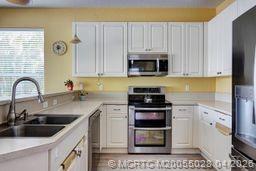 2120 Northwest Marsh Rabbit Lane Jensen Beach, FL 34957 - Photo 18 of 34 a kitchen with appliances a sink and a counter top space