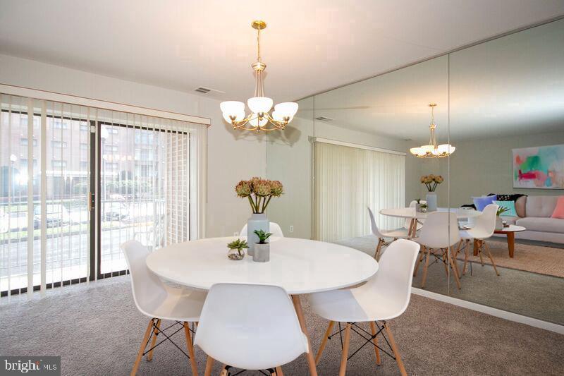 7202 Rockland Hills Drive, Unit 110 Baltimore, MD 21209 - Photo 7 of 13 a view of a dining room with furniture wooden floor and chandelier