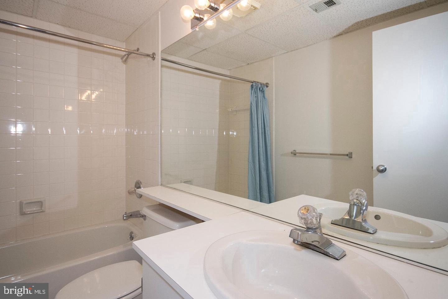 7202 Rockland Hills Drive, Unit 110 Baltimore, MD 21209 - Photo 10 of 13 a bathroom with a granite countertop sink toilet and shower