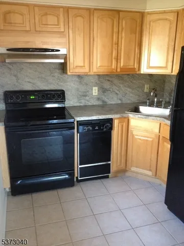 a kitchen with granite countertop a stove top oven and a sink