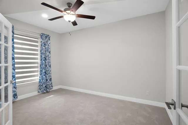 an empty room with windows and fan