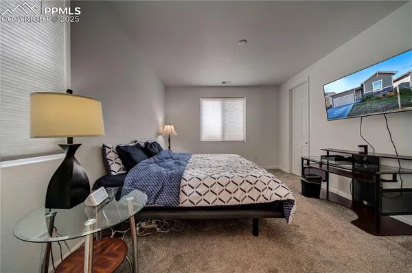 a bedroom with a bed gym equipment and view of living room