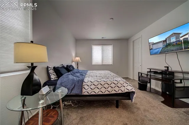 a bedroom with a bed gym equipment and view of living room