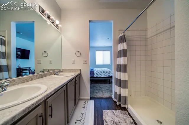 a bathroom with a granite countertop sink a mirror and shower