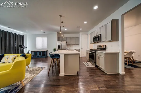 a kitchen with a sink appliances and wooden floor