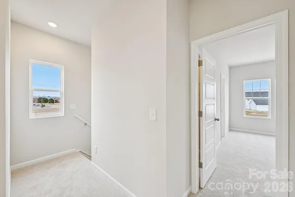 a view of a hallway with windows and closet