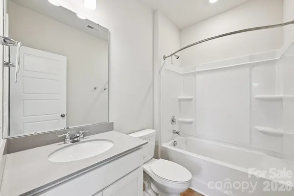 a bathroom with a granite countertop sink toilet mirror and shower