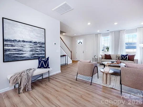 a living room with furniture and wooden floor