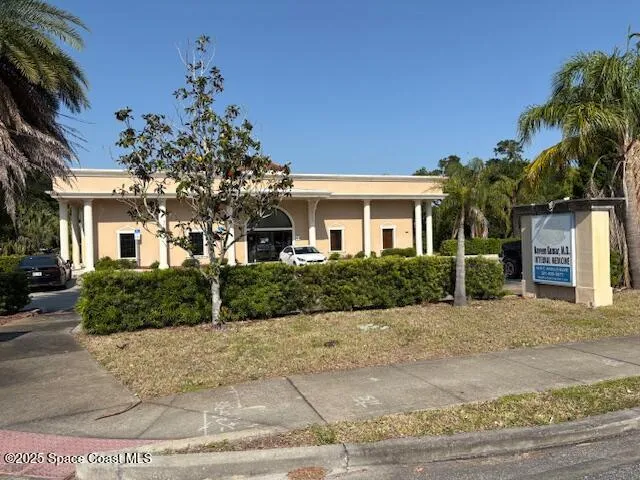 a front view of a house with a yard and potted plants