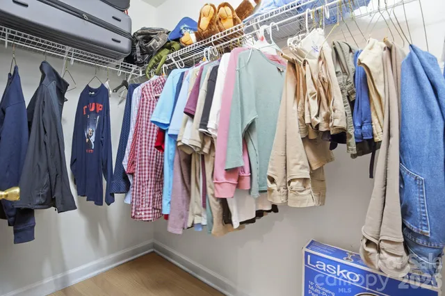 a view of walk in closet with clothes and shoes