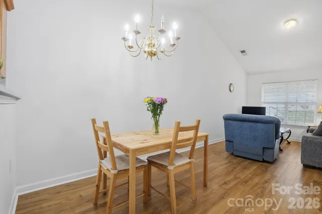 a dining room with furniture a chandelier and wooden floor