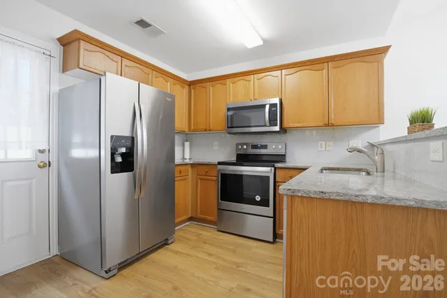 a kitchen with stainless steel appliances granite countertop a refrigerator stove and a sink