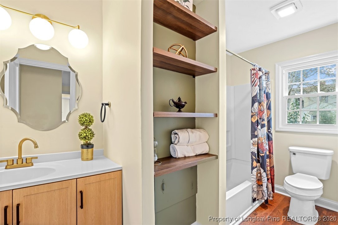 1605 Morganton Road Fayetteville, NC 28305 - Photo 14 of 30 a bathroom with a sink a toilet and a mirror