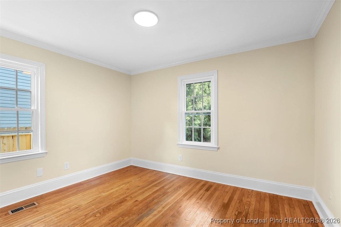 1605 Morganton Road Fayetteville, NC 28305 - Photo 9 of 30 an empty room with wooden floor and windows