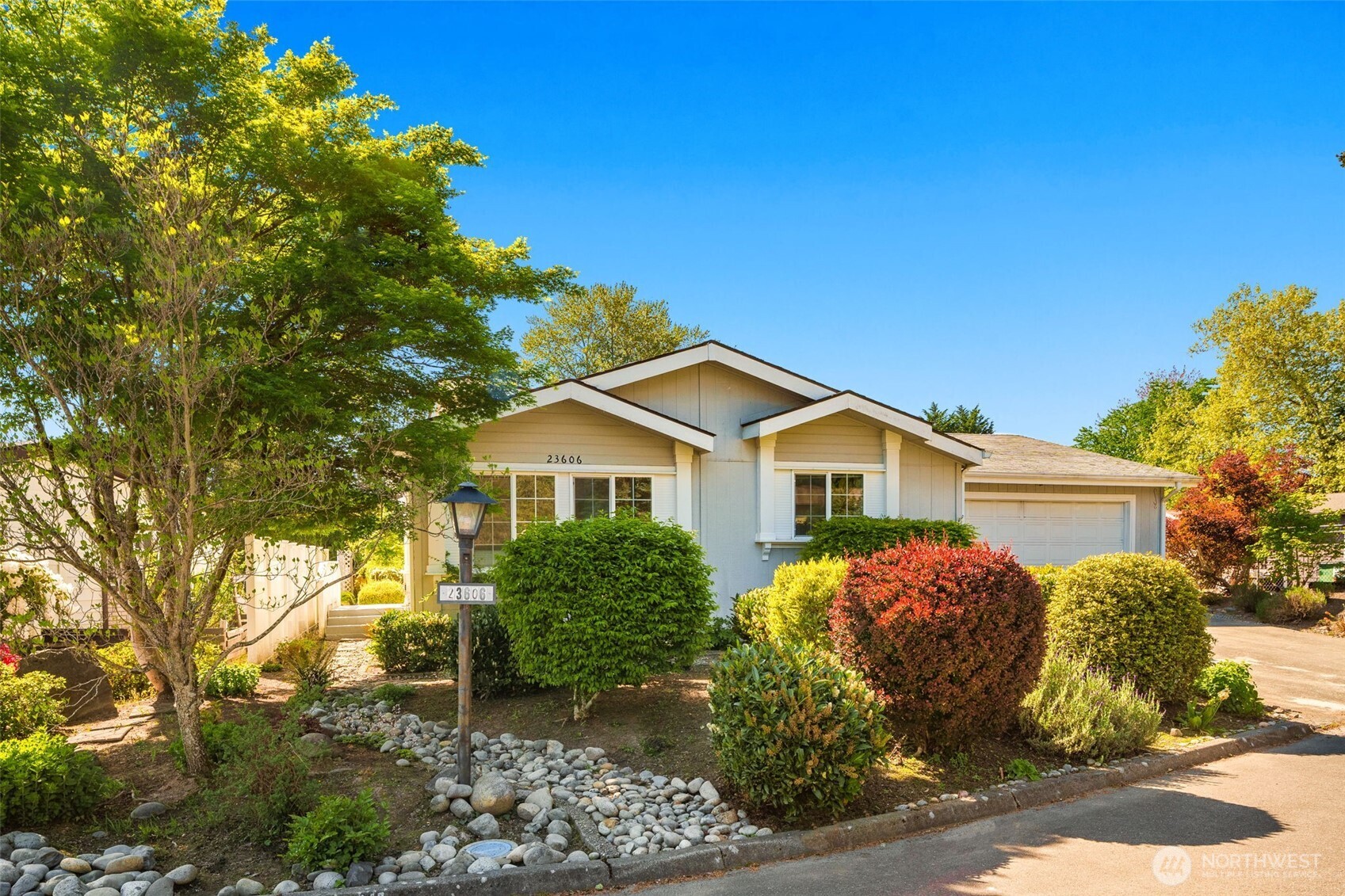 a view of a house with a yard and potted plants