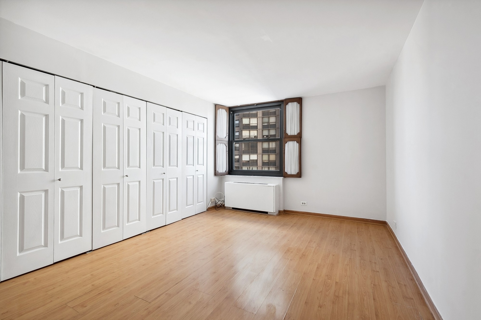 5701 North Sheridan Road, Unit 15R Chicago, IL 60660 - Photo 12 of 21 a view of an empty room with a window and wooden floor