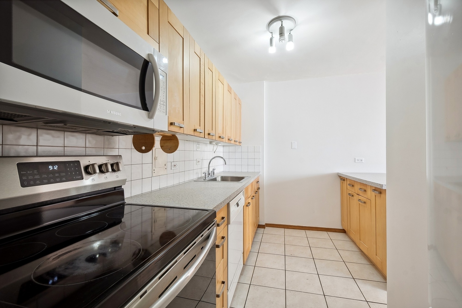 5701 North Sheridan Road, Unit 15R Chicago, IL 60660 - Photo 5 of 21 a kitchen with a sink stove and microwave