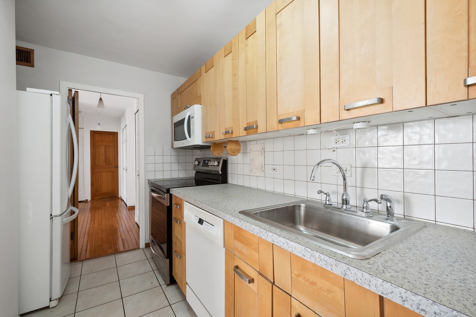 5701 North Sheridan Road, Unit 15R Chicago, IL 60660 - Photo 6 of 21 a kitchen with stainless steel appliances granite countertop a sink a refrigerator and a sink