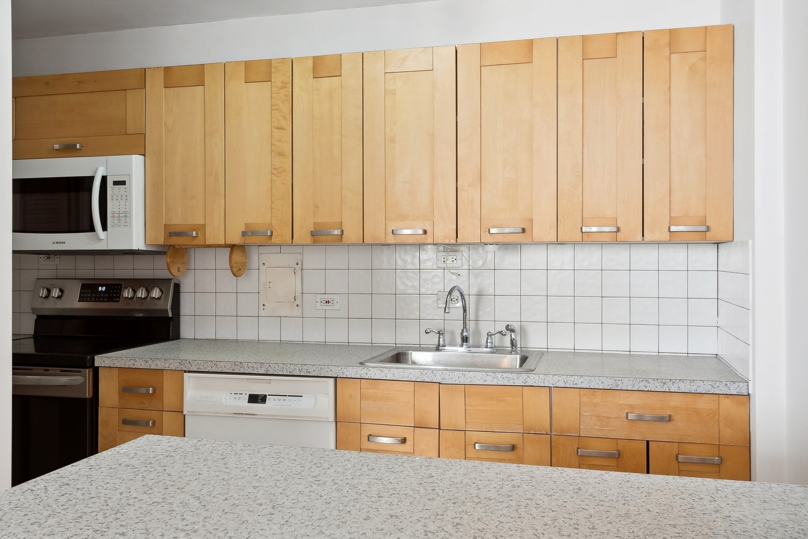 5701 North Sheridan Road, Unit 15R Chicago, IL 60660 - Photo 7 of 21 a kitchen with granite countertop a sink a stove and cabinets