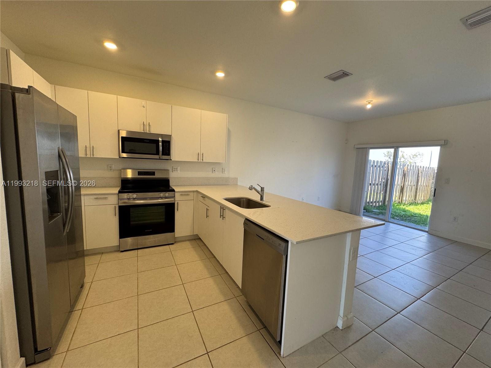 16227 Southwest 292nd Street Homestead, FL 33033 - Photo 7 of 28 a kitchen with a sink a counter top space cabinets and stainless steel appliances