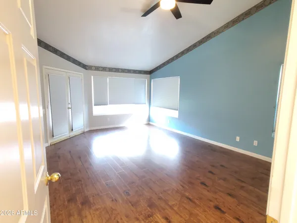 a view of empty room with wooden floor