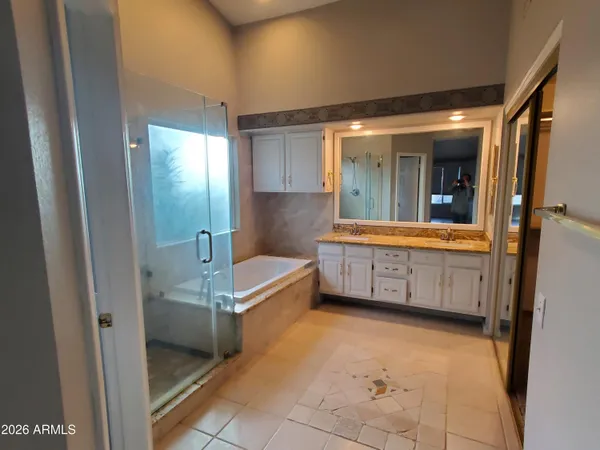a bathroom with a tub mirror and sink