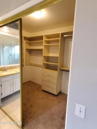 a view of walk in closet with clothes and shoes