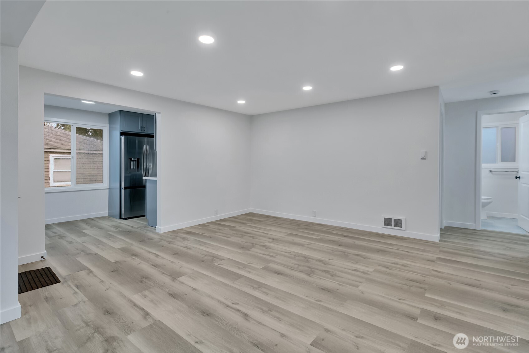 17017 4th Avenue Northeast Shoreline, WA 98155 - Photo 4 of 28 a view of an empty room with wooden floor and kitchen