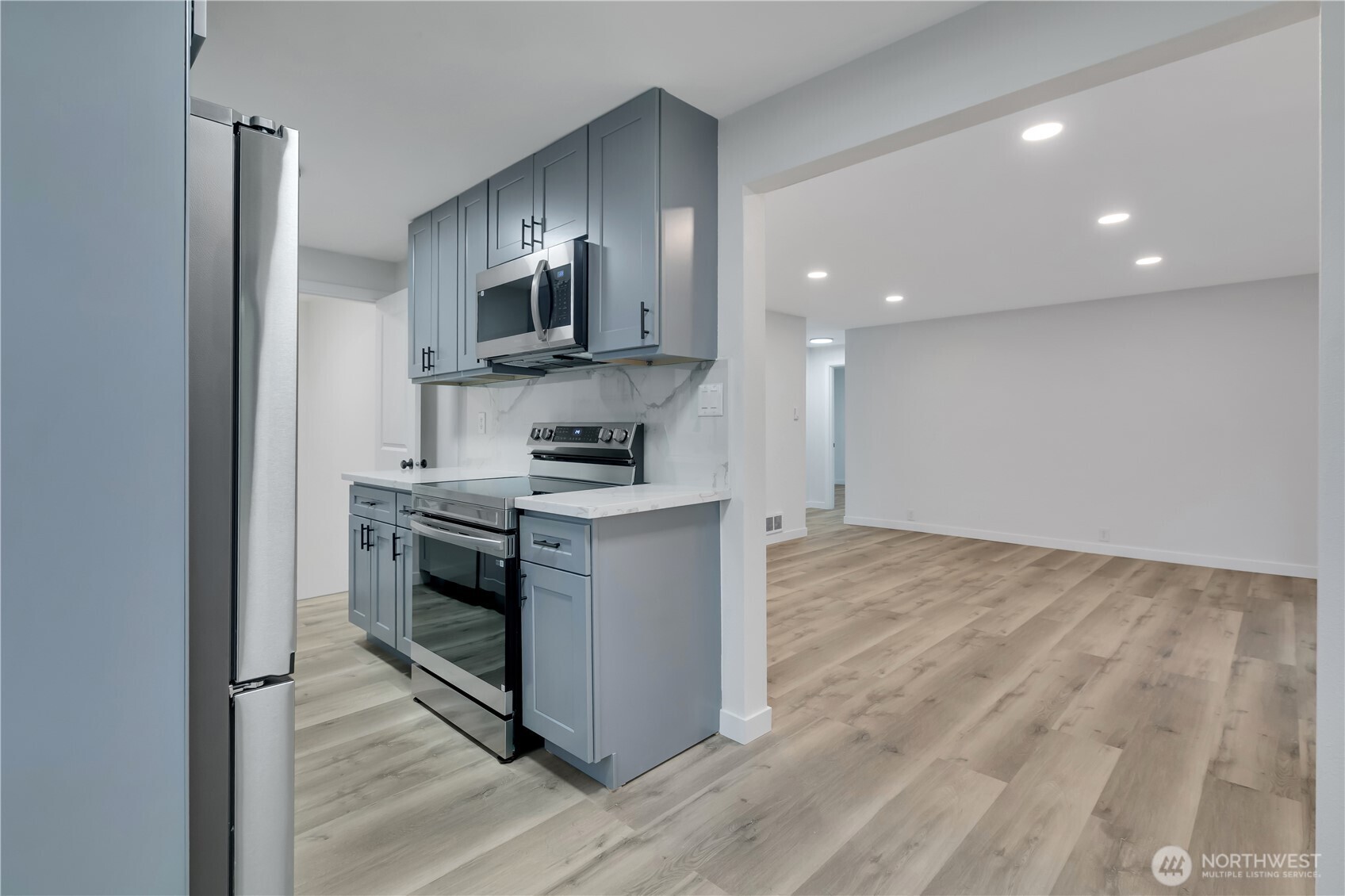 17017 4th Avenue Northeast Shoreline, WA 98155 - Photo 10 of 28 a kitchen with stainless steel appliances granite countertop a stove a sink and a refrigerator
