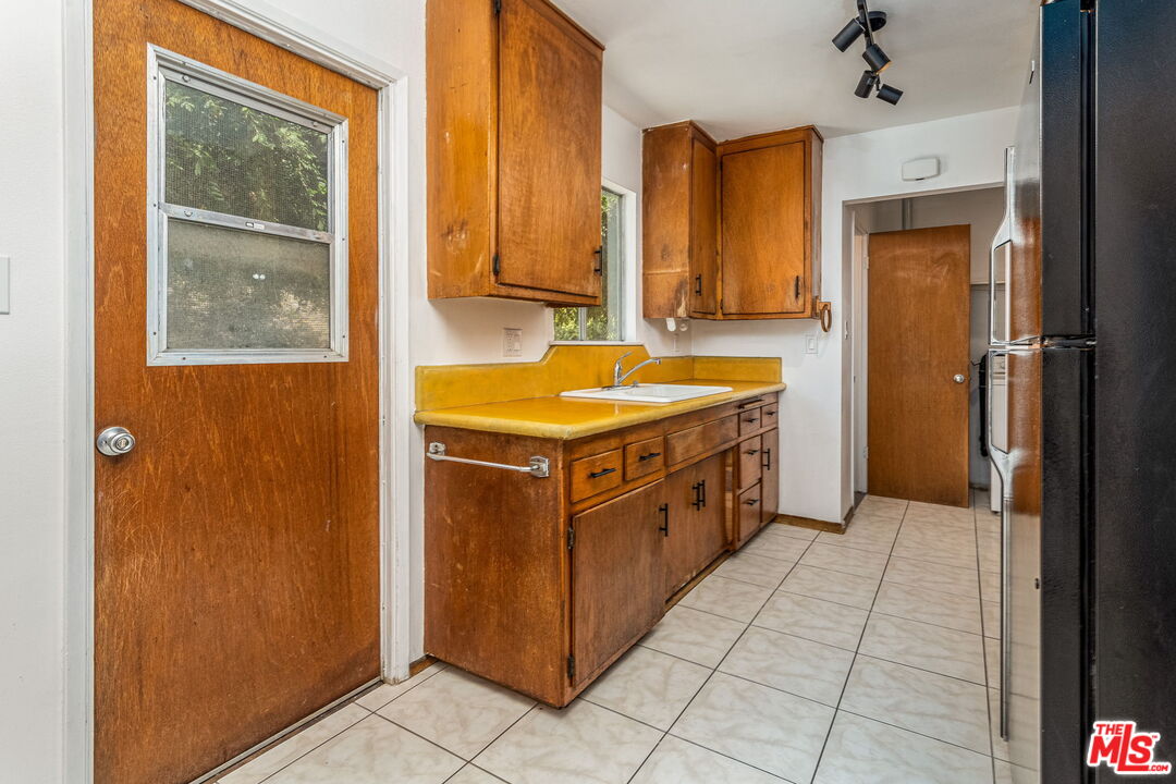 6352 Clyde Avenue San Diego, CA 92139 - Photo 11 of 30 a kitchen with stainless steel appliances granite countertop a sink and a refrigerator