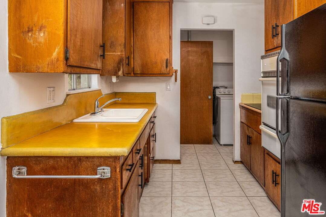 6352 Clyde Avenue San Diego, CA 92139 - Photo 12 of 30 a kitchen with a sink and refrigerator