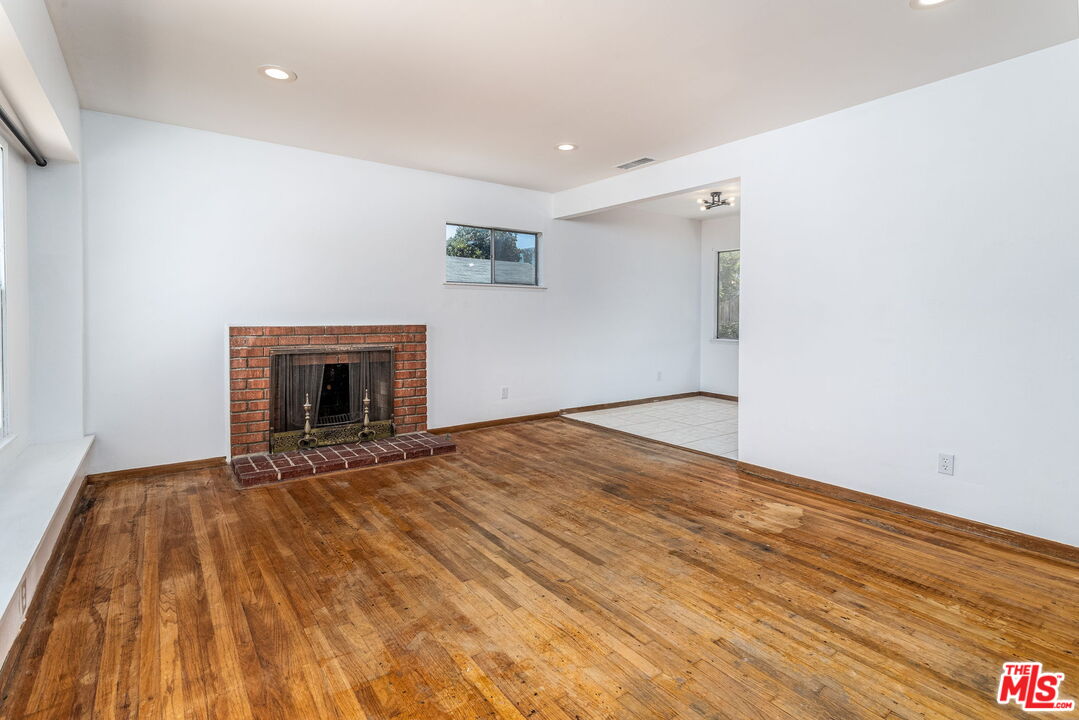 6352 Clyde Avenue San Diego, CA 92139 - Photo 5 of 30 a view of empty room with wooden floor and fireplace