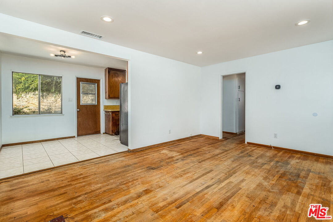 6352 Clyde Avenue San Diego, CA 92139 - Photo 7 of 30 a view of an empty room with window and wooden floor