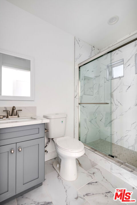 10803 Kling Street Toluca Lake, CA 91602 - Photo 18 of 25 a bathroom with a granite countertop sink toilet and shower