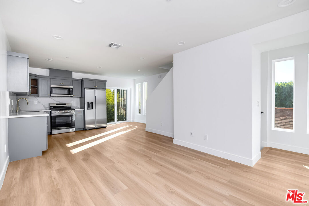 10803 Kling Street Toluca Lake, CA 91602 - Photo 20 of 25 a view of a kitchen with refrigerator stove and wooden floor