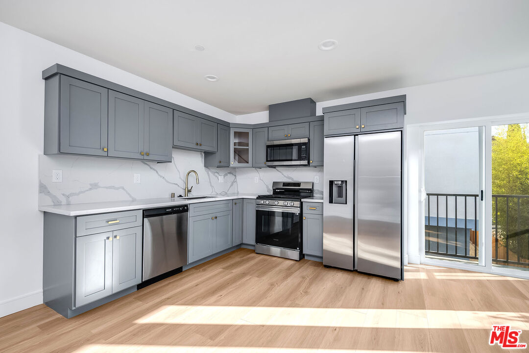 10803 Kling Street Toluca Lake, CA 91602 - Photo 21 of 25 a kitchen with granite countertop a refrigerator stove top oven and sink