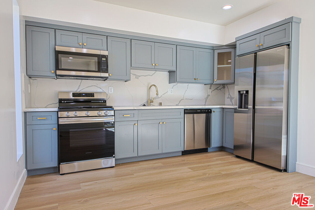10803 Kling Street Toluca Lake, CA 91602 - Photo 6 of 25 a kitchen with a sink stove and refrigerator
