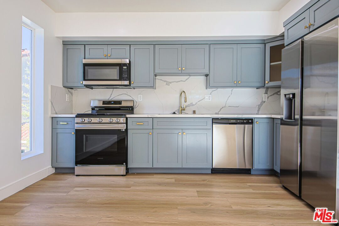 10803 Kling Street Toluca Lake, CA 91602 - Photo 7 of 25 a kitchen with a sink stove and refrigerator
