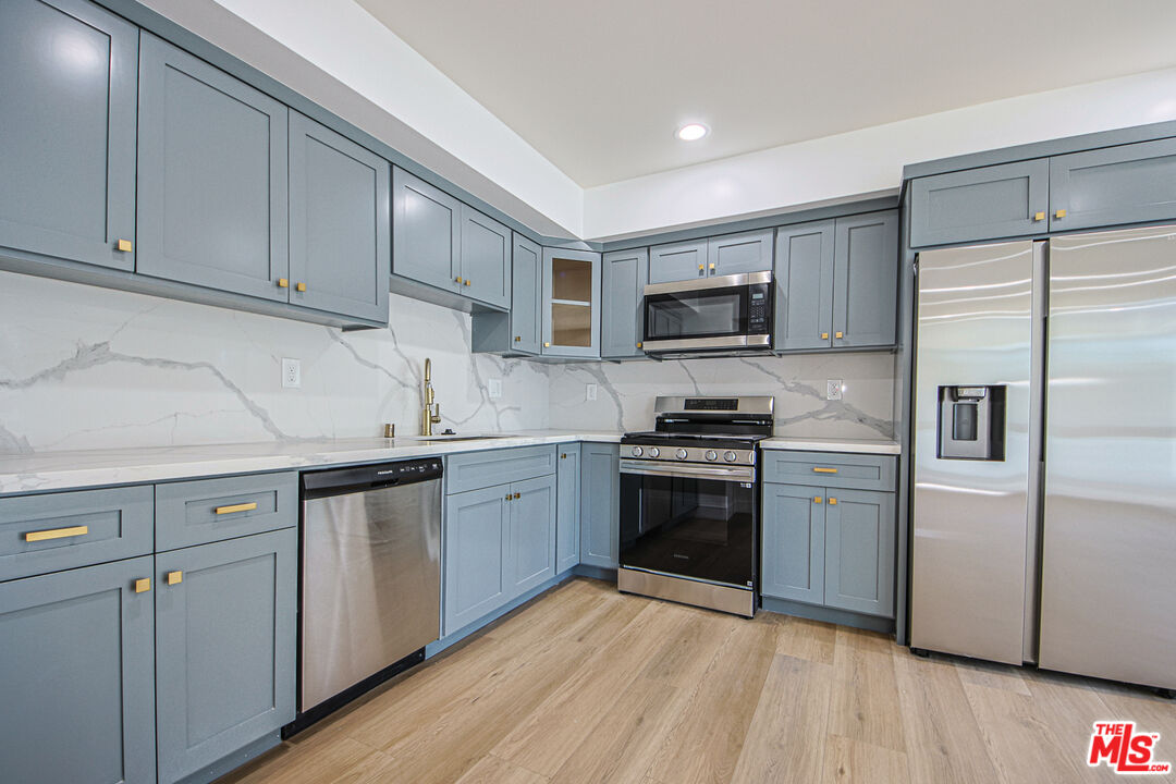 10803 Kling Street Toluca Lake, CA 91602 - Photo 8 of 25 a kitchen with granite countertop a refrigerator stove and sink
