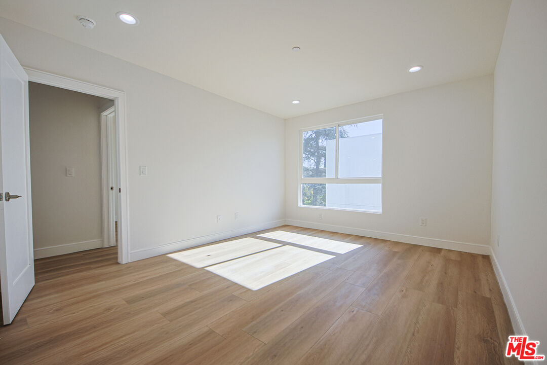 10803 Kling Street Toluca Lake, CA 91602 - Photo 10 of 25 an empty room with wooden floor and windows