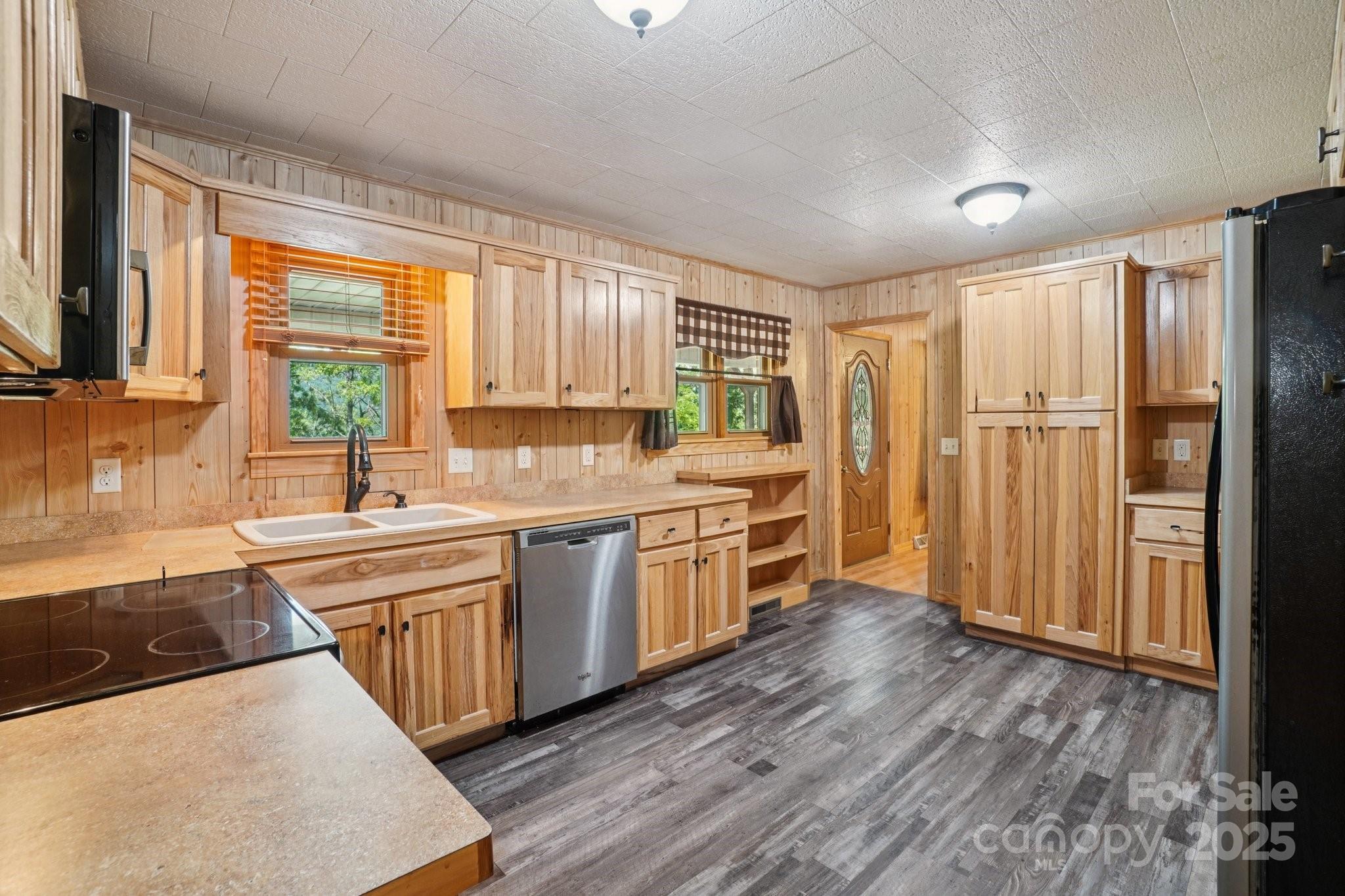 623 Edwards Cove Road Waynesville, NC 28786 - Photo 16 of 46 a kitchen with stainless steel appliances granite countertop a refrigerator a sink dishwasher a stove and white countertops with wooden floor