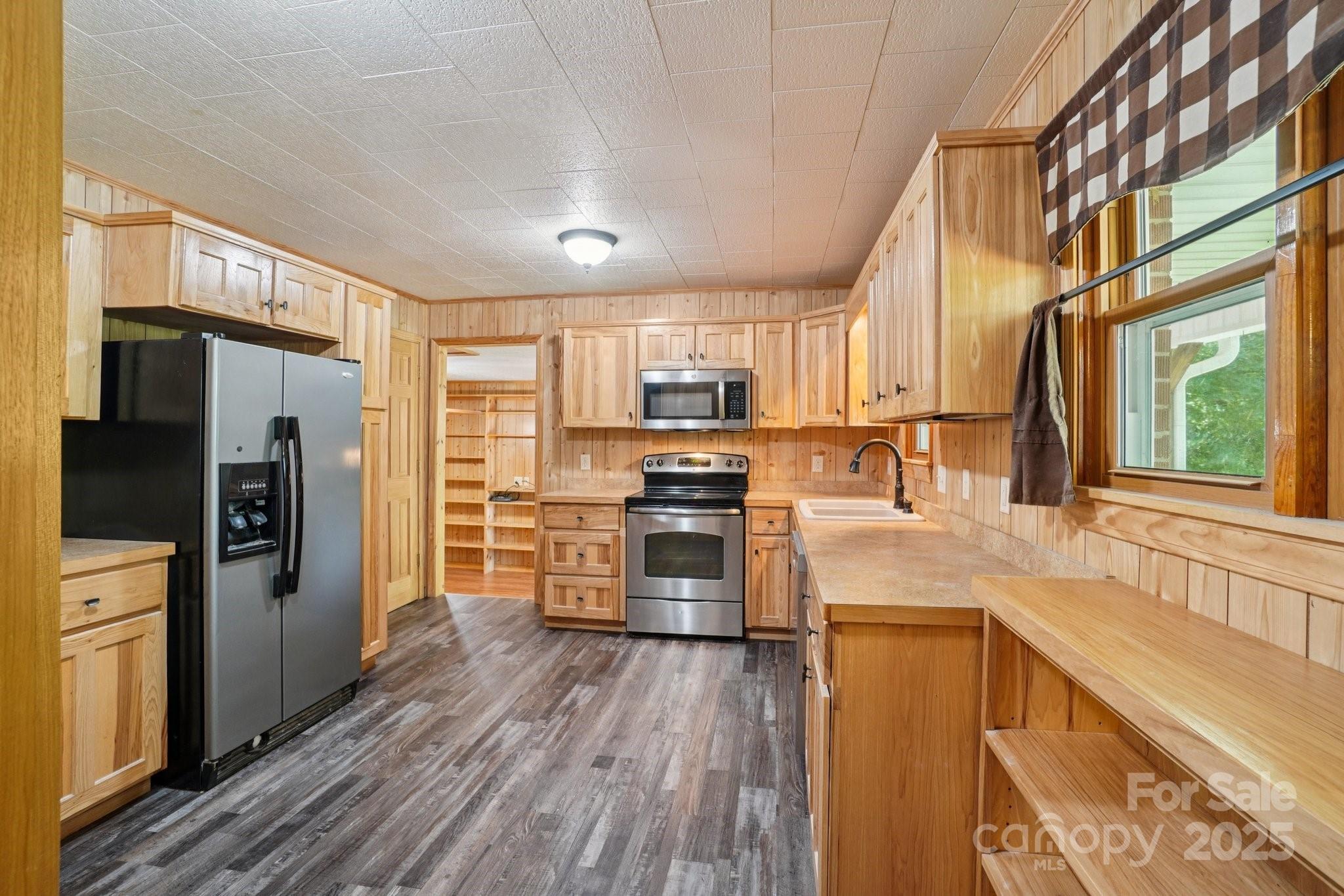 623 Edwards Cove Road Waynesville, NC 28786 - Photo 17 of 46 a kitchen with stainless steel appliances granite countertop a refrigerator a sink dishwasher a stove and white countertops with wooden floor