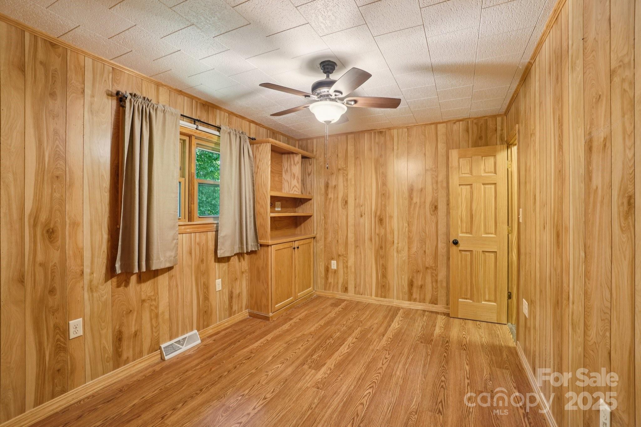 623 Edwards Cove Road Waynesville, NC 28786 - Photo 23 of 46 a view of a livingroom with wooden floor and a ceiling fan