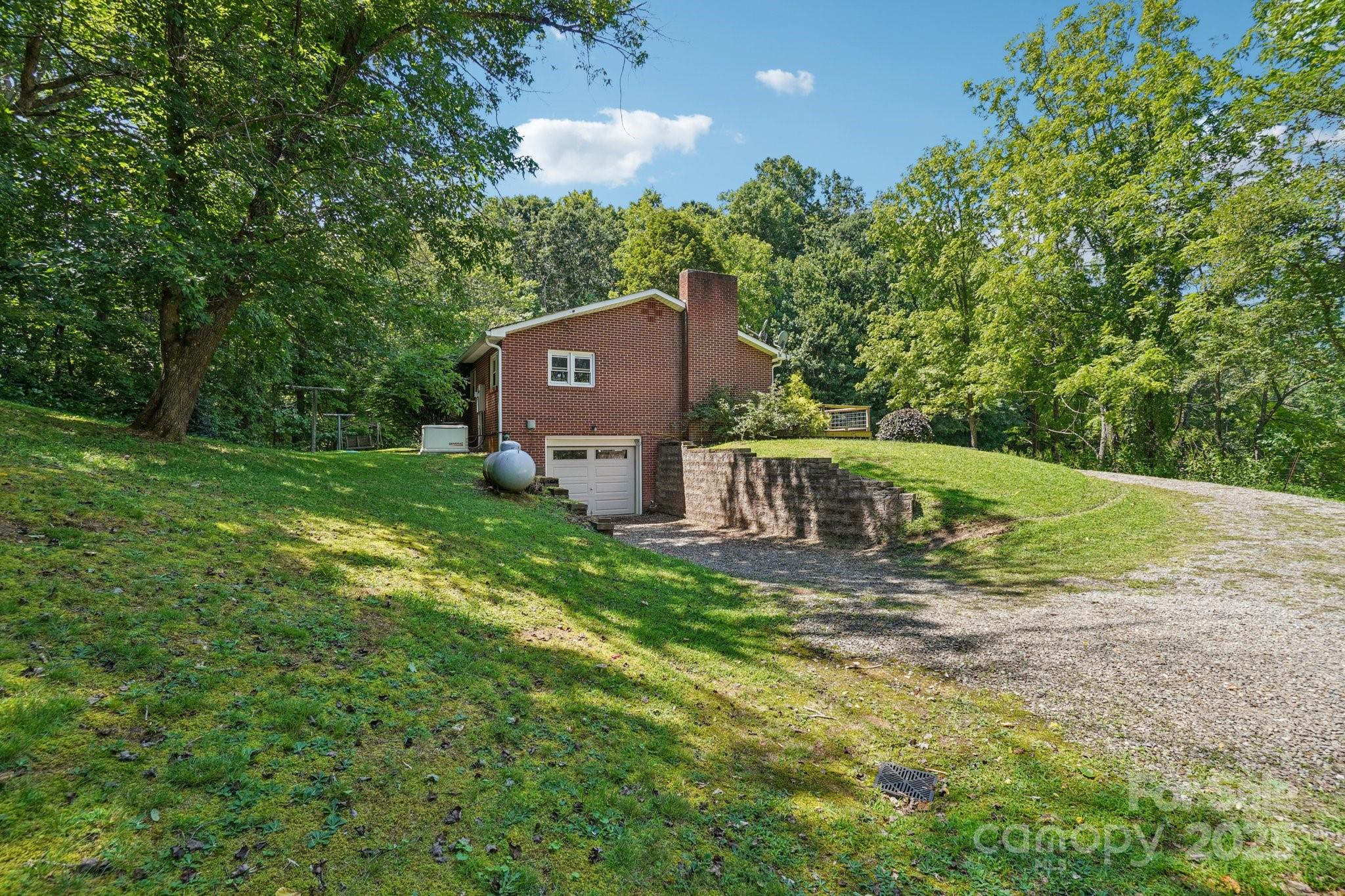 623 Edwards Cove Road Waynesville, NC 28786 - Photo 36 of 46 a view of a house with a big yard and large trees