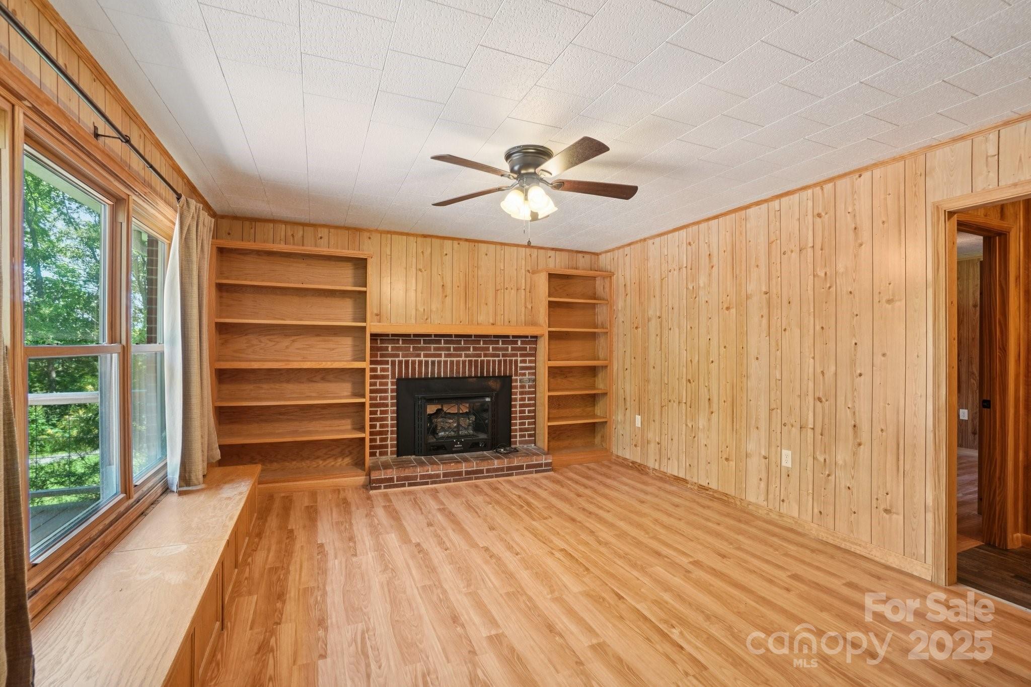 623 Edwards Cove Road Waynesville, NC 28786 - Photo 5 of 46 a view of livingroom with a fireplace a ceiling fan and front door